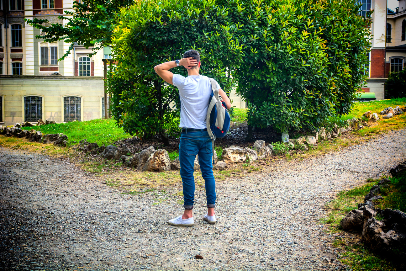 Young man facing choice between two different paths